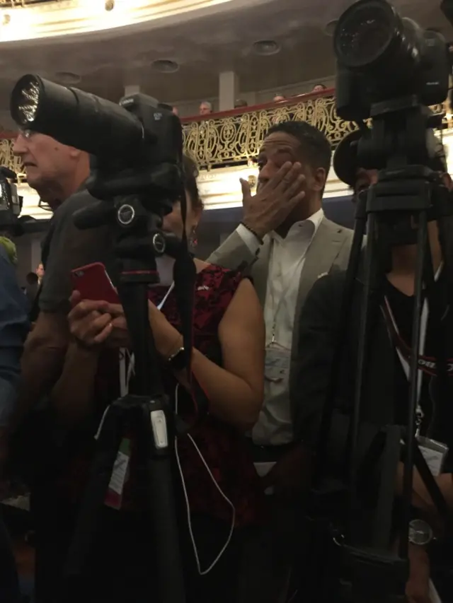 A Cuban American wipes away tears as President Obama speaks about the pain of exile and the need for reconciliation