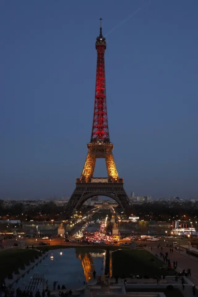 The Eiffel Tower is lit in black, yellow and red - the colours of the Belgian national flag