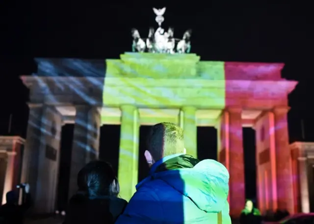 Colours of the Belgian flag projected on to the Brandenburg Gate in Berlin