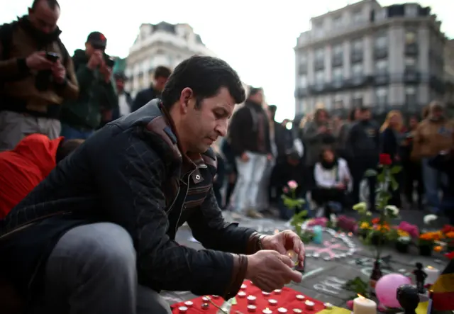 People leave tributes at Brussel's Place de la Bourse following the attacks on the city