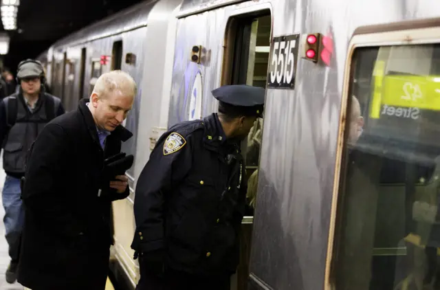 A New York City police officer patrols a subway car at the Times Square/42nd Street station of the New York City metro system