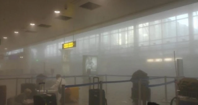 Passengers react in the smoke-filled aftermath of the Brussels terror bomb attacks at Zaventum Airport