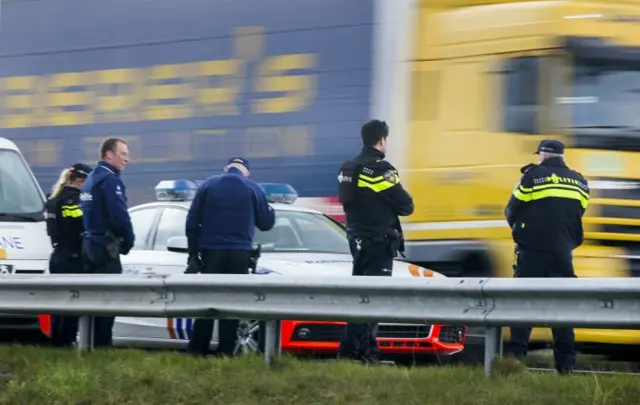 Dutch and Belgian police officers monitor a motorway close to the Hazeldonk border crossing between Belgium and the Netherlands