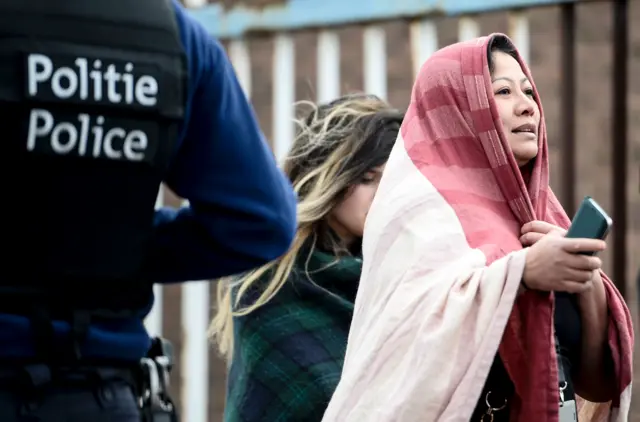 Woman reacts as she is evacuated from Brussels airport in Zaventem