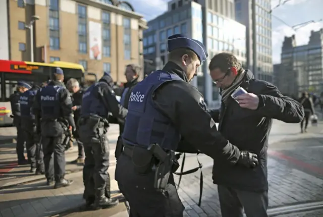 Police officers check people outside Brussels Midi train station