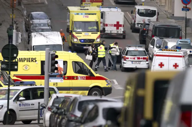 Emergency services evacuate a woman after a explosion in a main metro station in Brussels on Tuesday, March 22, 2016