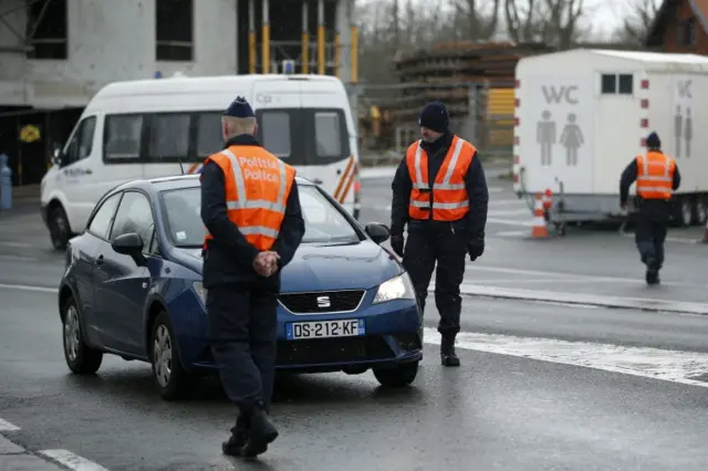 Belgian police officers check cars at the border between France and Belgium near Bray-Dunes, in France