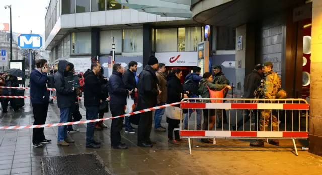 Armed soldiers check the bags of commuters as a Metro station near Place de la Bourse, Brussels, on 23 March 2016