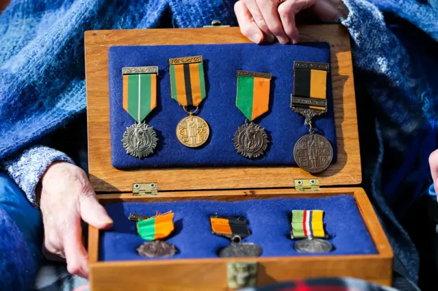 Sheila O'Leary holds a box of her father's medals