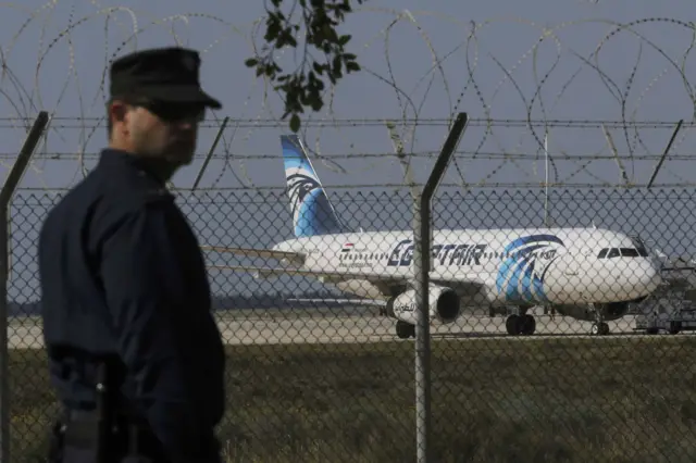 A policeman stands guard at Larnaca Airport near a hijacked Egypt Air A320 , March 29, 2016.