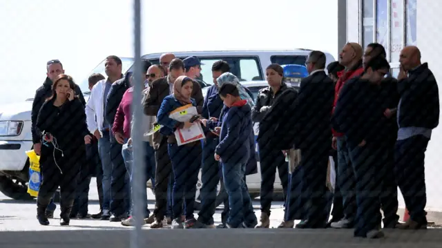 Passengers of an EgyptAir Airbus A-320 which was hijacked and diverted to Cyprus stand at Larnaca airport after disembarking the plane