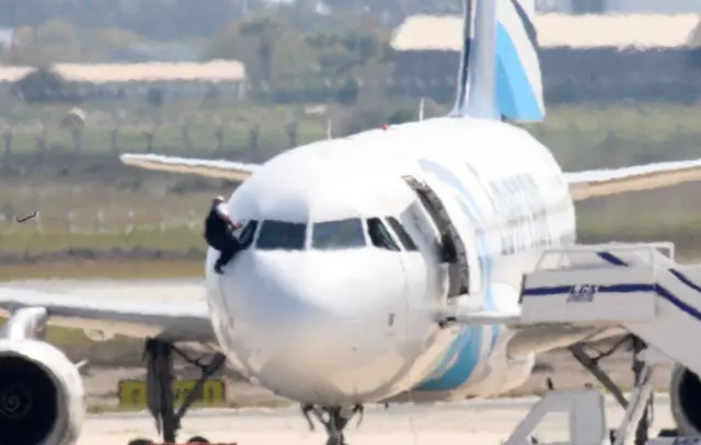 Crew member climbs out of cockpit window