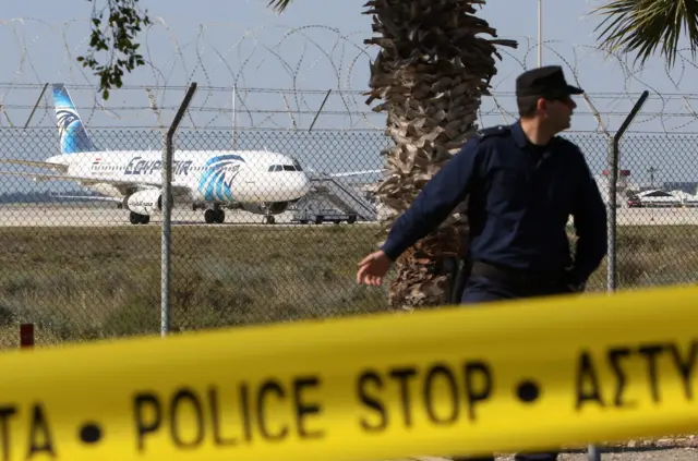 A Cypriot policeman stands guard near a hijacked EgyptAir A320 plane at Larnaca Airport, in Larnaca, Cyprus