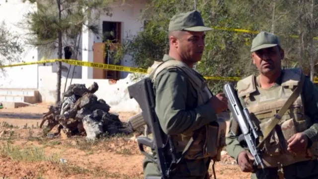 Tunisian soldiers stand guard at the scene of an assault near the border town of Ben Guerdan