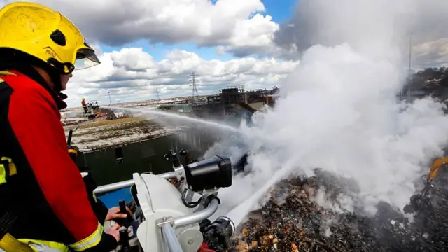 Firefighter pouring water on fire