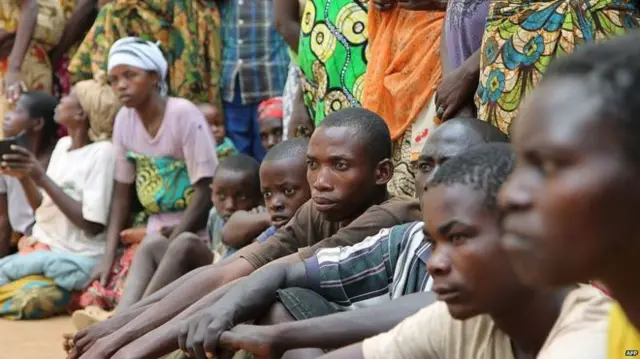 Burundian refugees sitting in a camp