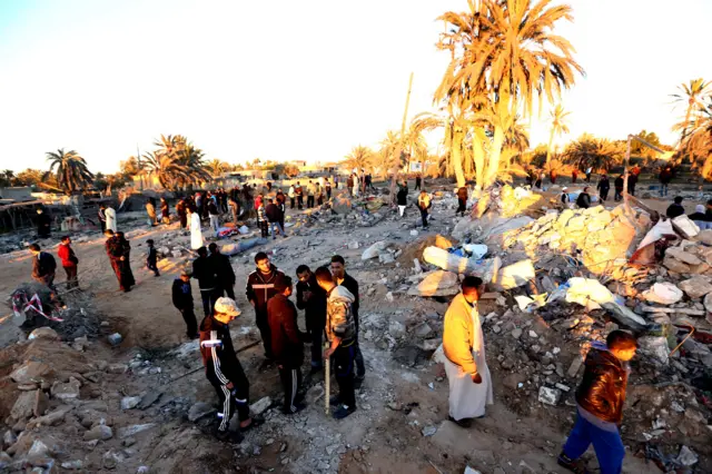 Libyans gather next to debris at the site of a jihadist training camp, targeted in a US air strike, near the Libyan city of Sabratha on February 19, 2016.