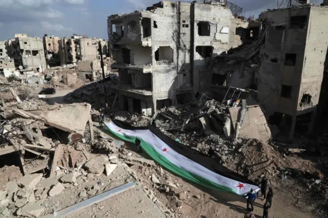 Residents of Jobar, on the outskirts of Damascus, display an opposition flag