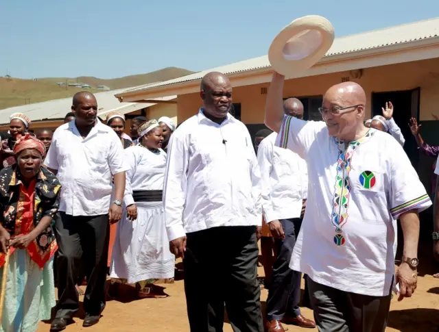 South African president and leader of the ruling African National Congress (ANC) party Jacob Zuma (R), greets voters who register at the Halambu Primary School in his rural village of Nkandla, on March 5, 2016