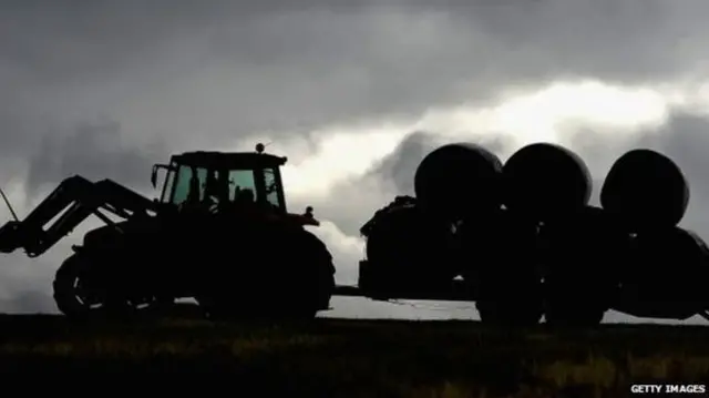 Tractor hauling bails of hay