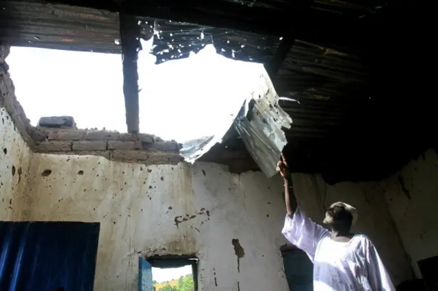 A Sudanese man points to damages at his house caused by fighting that erupted in June between government forces and ex-rebels with strong ties to South Sudan, in Kadugli in the tense border region of South Kordofan on October 21, 2011