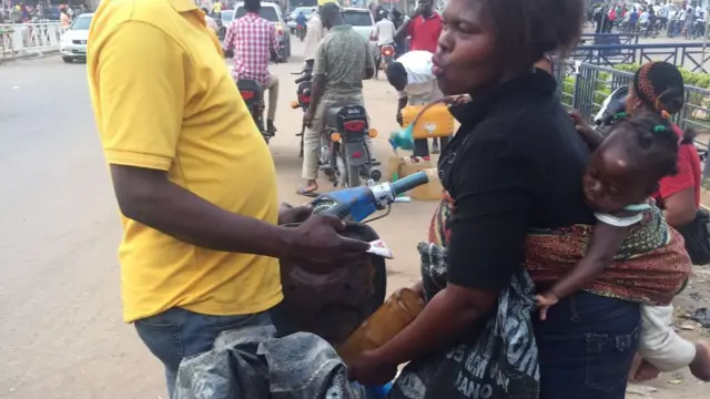 Female petrol vendor in Abuja, Nigeria