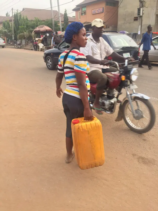 Female petrol vendor in Abuja, Nigeria