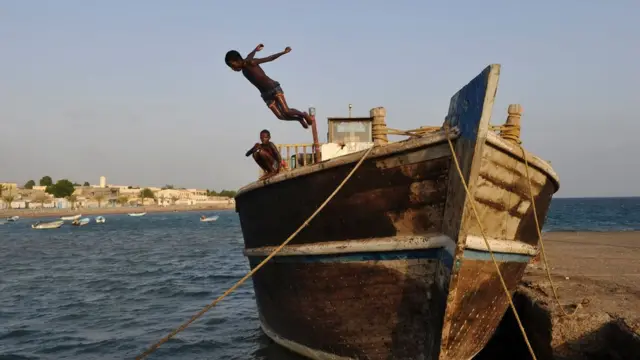 Young boys dive into the sea from a boat, on March 25, 2016 in Tadjoura, north central Djibouti.