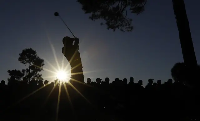 A golfer plays a shot at the 18th hole