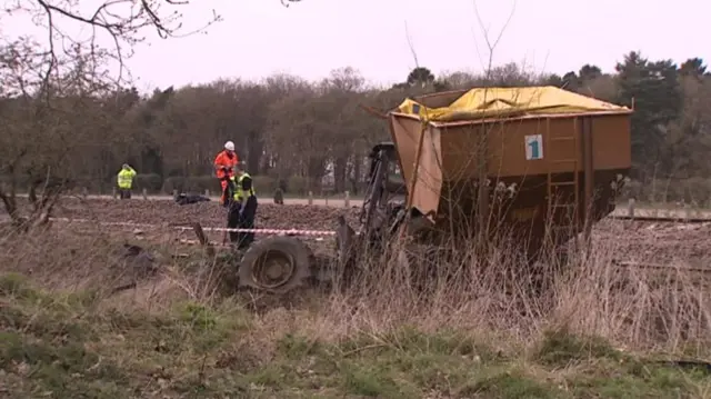 The damaged tractor, and emergency services