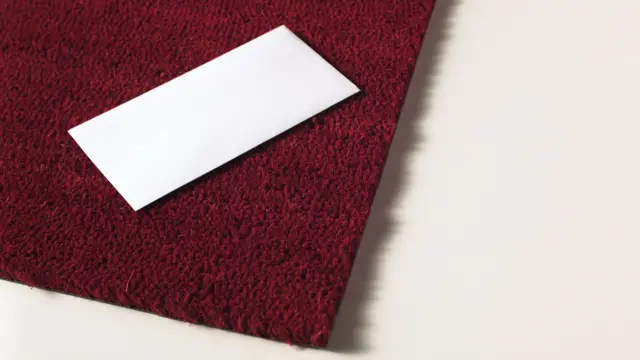 White envelope on a red mat