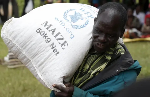 A Malawian man carries food aid distributed by the United Nations World Food Progamme (WFP) in Mzumazi village near the capital Lilongwe, February 3, 2016