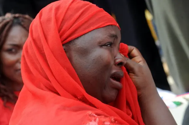 ne of the mothers of the missing Chibok school girls wipes her tears as she cries during a rally by civil society groups pressing for the release of the girls in Abuja on May 6, 2014