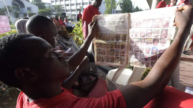 People reading a paper about the Chibok girls in Lagos, Nigeria - 14 May 2016