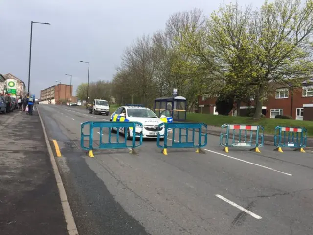 Road blocks and police car in middle of street