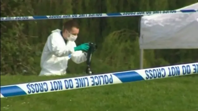 Forensic officer takes pictures at scene