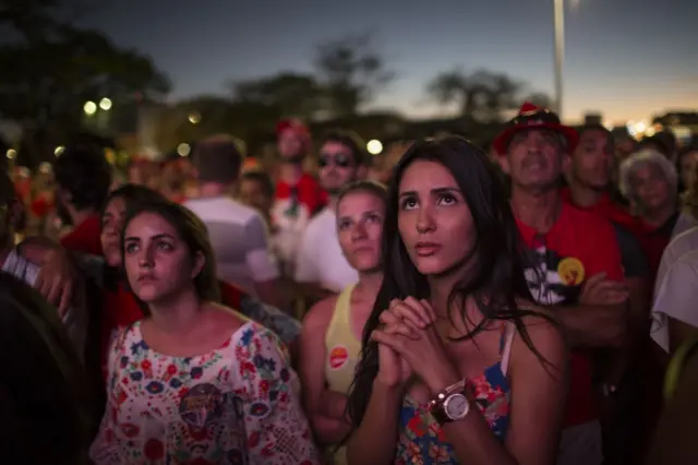 Pro-government demonstrators watch on a large screen, as lawmakers vote on whether or not to impeach President Dilma Rousseff, in Brasilia, Brazil, Sunday, April 17, 2016