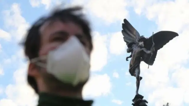 Protesters have placed surgical masks on famous London statues, including Eros in Piccadilly Circus