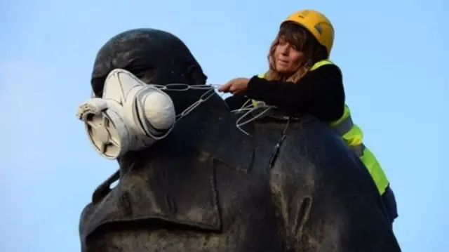 Protesters placed a mimic of a gas mask over the Winston Churchill statue outside Parliament