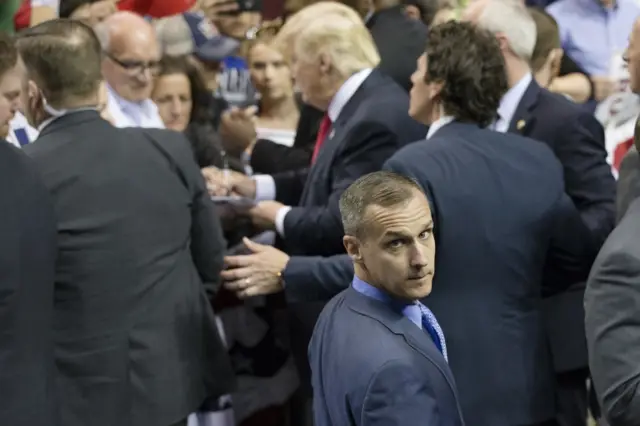 Corey Lewandowski stands as Donald Trump sign autographs on 18 April 2016, in Buffalo, New York