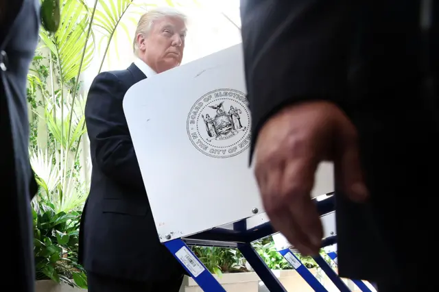 Security agents stand close as Republican Presidential candidate Donald Trump votes at his local polling station in New York"s primary on 19 April 2016