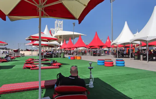 A fan enjoys smoking water pipe at the Formula 1 Bahrain International Circuit