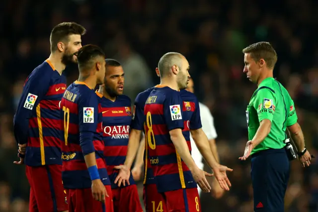 Barcelona players surround referee