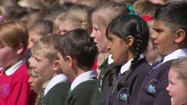 School children singing for the Queen