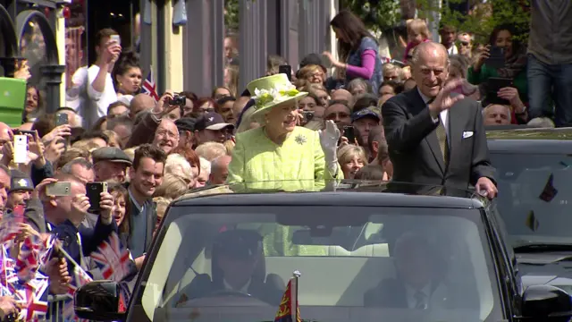 Queen and Prince Philip wave at crowds