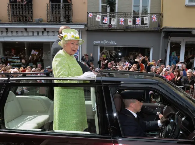 Queen in an open-top car