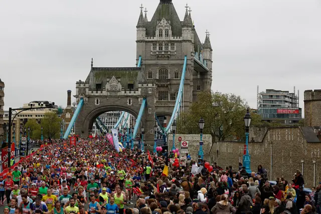 masses of people running and watching at London's Tower Bridge