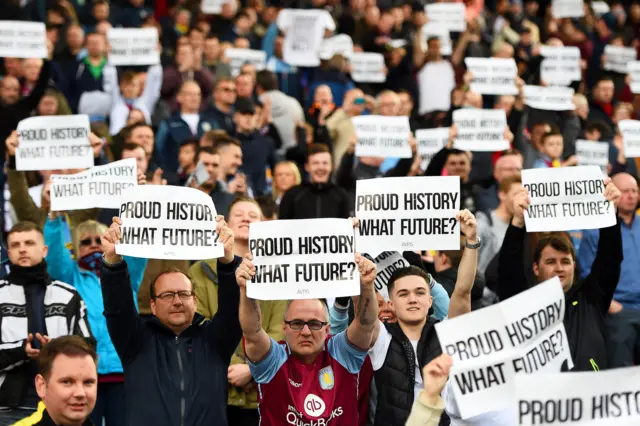 Aston Villa fans hold signs