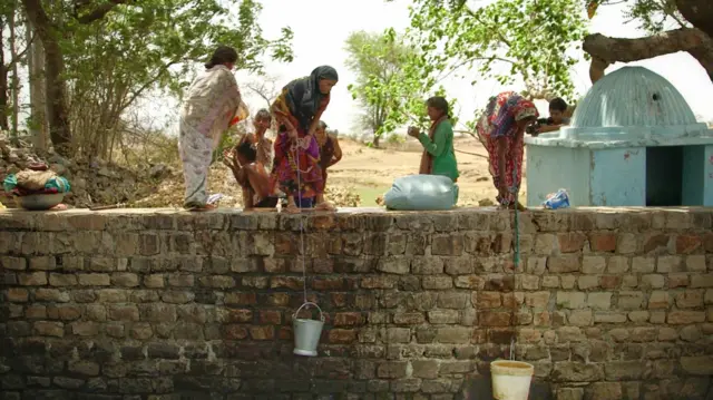 Women collecting buckets of water in Gopipur village in the Indian state of Uttar Pradesh