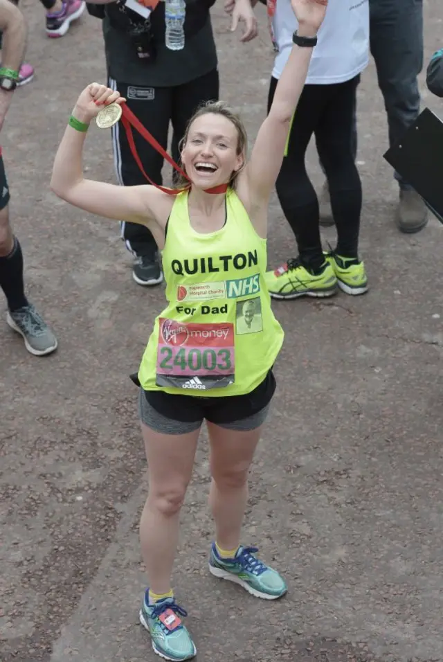 A runner celebrates reaching the finish line